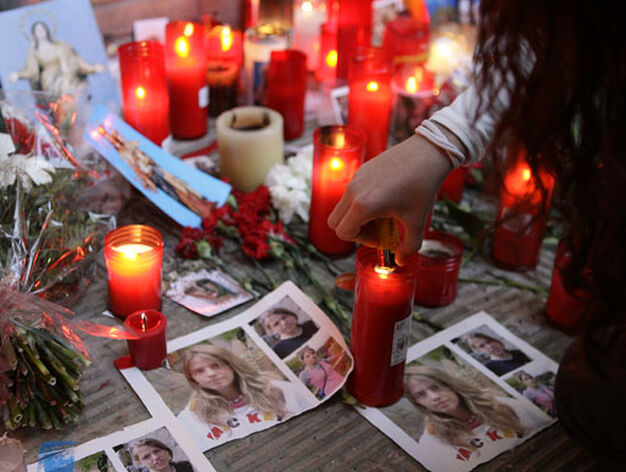 Una joven enciende una vela bajo una foto de Marta.

Foto: Antonio Pizarro / Manuel G&oacute;mez