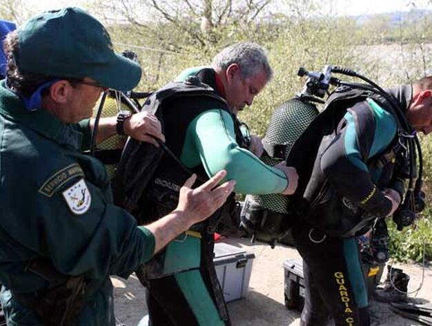 Un agente de la Guardia Civil ayuda a los buzos a colocarse la bombona de ox&iacute;geno.

Foto: Juan Carlos Mu&ntilde;oz