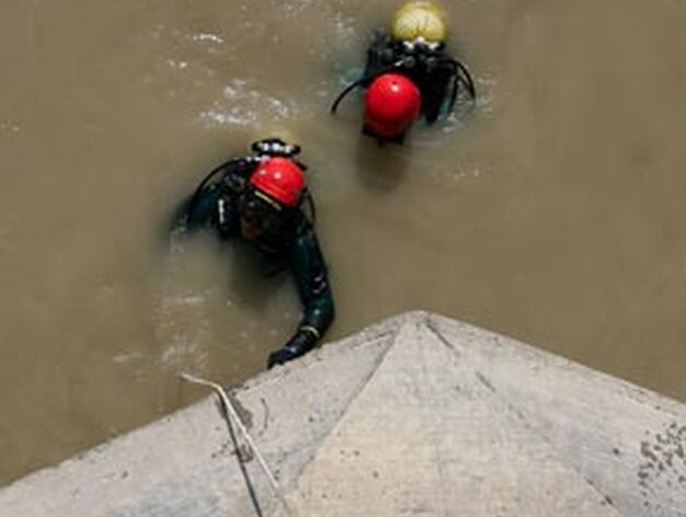 Un agente de la Guardia Civil ayuda a los buzos a salir del agua.

Foto: Juan Carlos Mu&ntilde;oz