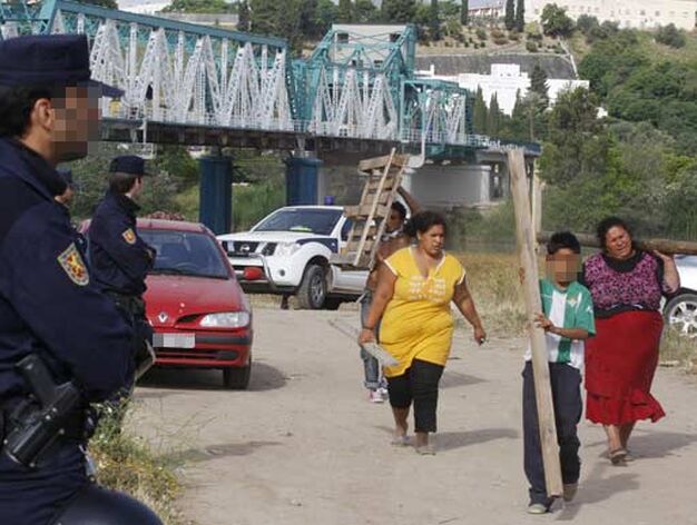 Chabolistas trasladas maderas del puente de hierro de San Juan ante la mirada de varios agentes.

Foto: Jose Angel Garcia - Victoria Hidalgo