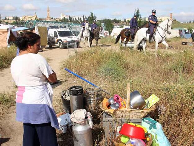 Un mujer observa algunas pertenencias mientras avanzan agentes a caballo.

Foto: Jose Angel Garcia - Victoria Hidalgo