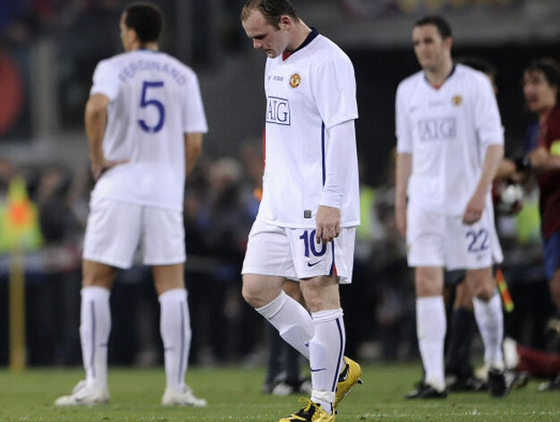 Wayne Rooney, cabizbajo mientras los azulgranas recog&iacute;an el trofeo de mano de Platini