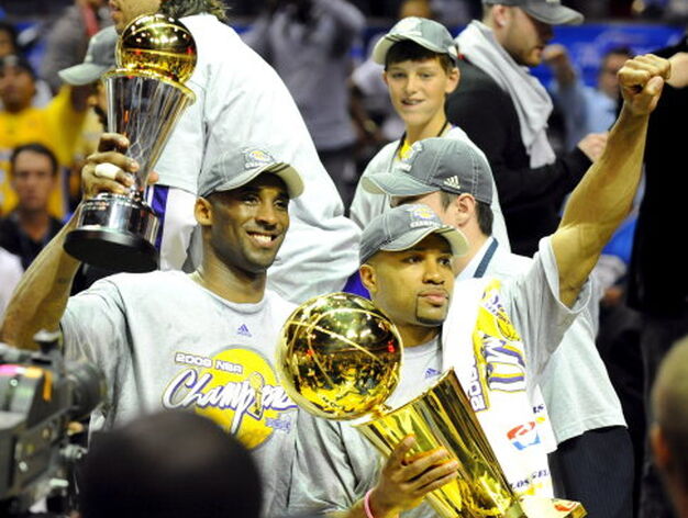 Bryant (i) y el base Fisher (d) muestra las copas de MVP de la final y campe&oacute;n de la NBA, respectivamente.