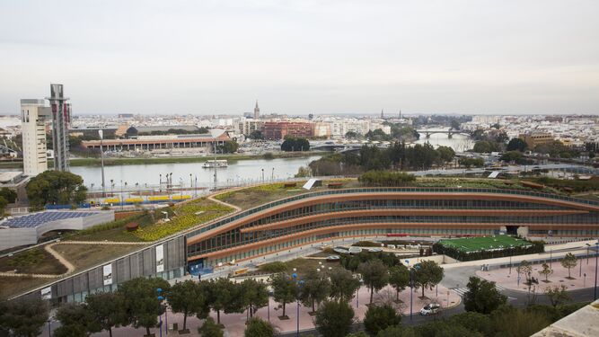 El Caixafórum de Sevilla, a la izquierda de la imagen, y al fondo el parque de ribera que se conoce como el complejo Torre Sevilla con el río.
