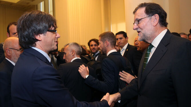 Puigdemont y Rajoy se saludan en un acto reciente.