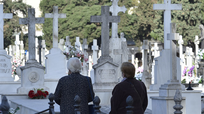 Dos señoras ante varias tumbas en el cementerio de San Fernando.