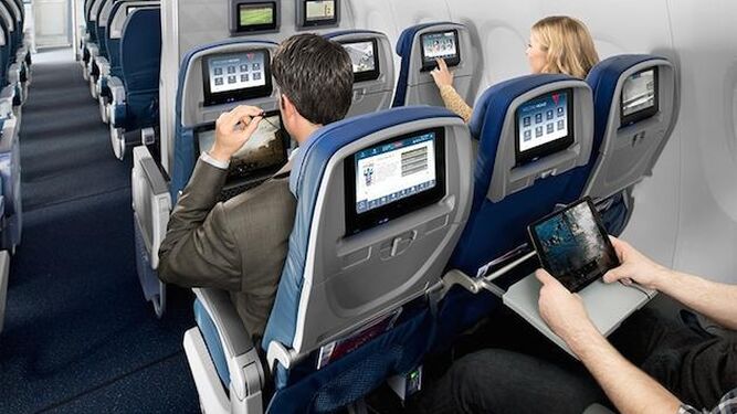 Un viajero usa una 'tablet' en un avión.