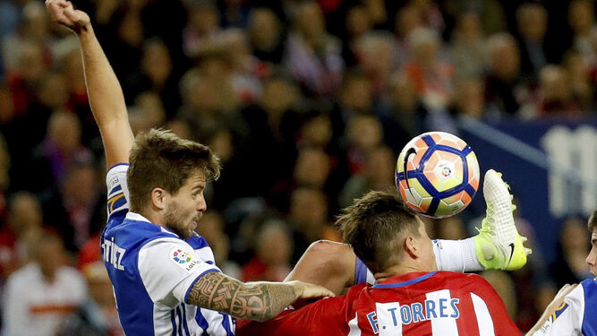 Íñigo Martínez le quita de la cabeza una pelota a Torres en un partido con el Atlético