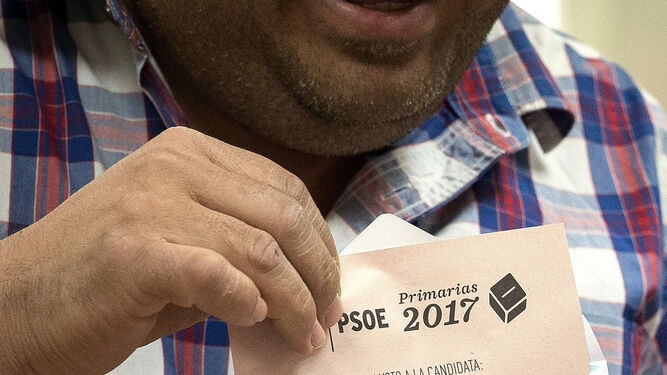 Un militante muestra la papeleta con el nombre de Susana Díaz en la sede de la agrupación del PSOE de Triana.