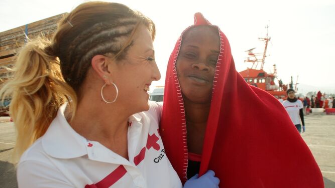 Una voluntaria de Cruz Roja atiende a una de las ocupantes de la embarcación.
