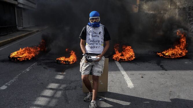 Un manifestante ante una barricada en llamas durante una manifestación el jueves en Caracas.