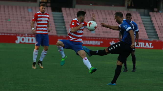 Un jugador del Granada B se interpone en el despeje de un futbolista del Mérida en un duelo de la presente temporada.