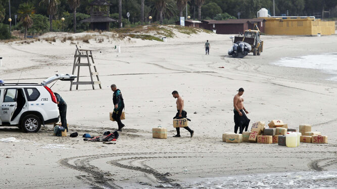 Agentes de la Guardia Civil transportando fardos incautados en una playa de la provincia.
