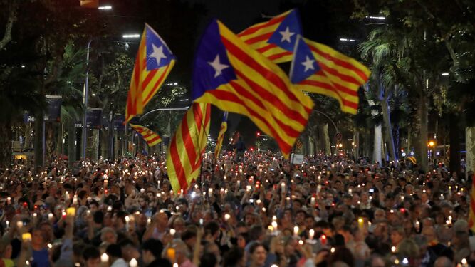 Miles de persona con banderas secesionistas y velas encendidas