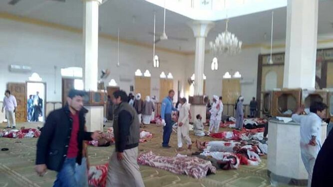 Varias personas, junto a varios cuerpos sin vida en la mezquita atacada en Egipto