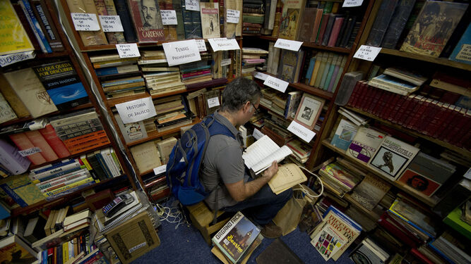 Un visitante de la FIL hojea libros en una de las casetas del recinto.