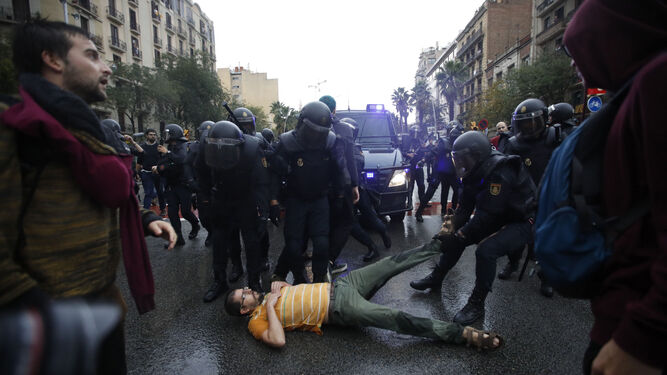 Antidisturbios arrastran a un manifestante en Barcelona durante la consulta ilegal del 1 de octubre.