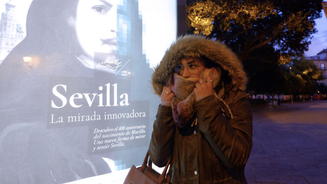Una joven se resguarda del frío en Sevilla