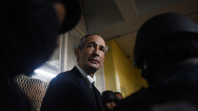 El ex presidente de Guatemala Álvaro Colom camina escoltado tras ser capturado.