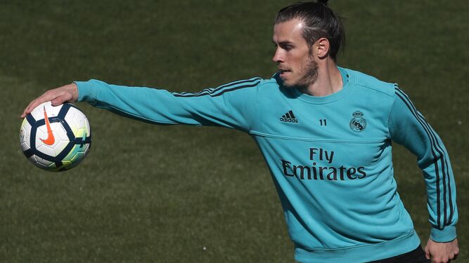 El delantero del Real Madrid Gareth Bale atrapa un balón durante el entrenamiento de su equipo en Valdebebas.