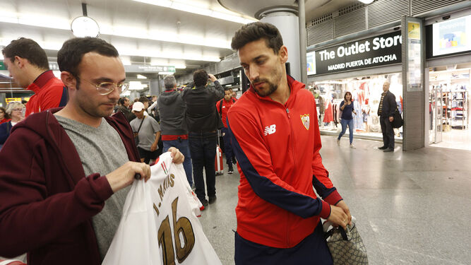 Jesús Navas se dispone a firmarle una camiseta con su nombre a un aficionado sevillista en Atocha.