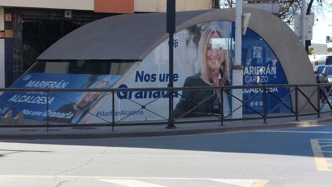 Imagen de una boca del Metro de Granada vinilada con la campaña del PP