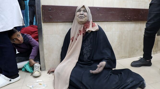 Una mujer herida se lamenta en el suelo de un hospital de Dair el Balah.