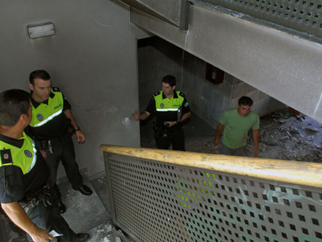 Varios agentes de la polic&iacute;a local en las escaleras que da acceso a las plantas del bloque incendiado./ Manuel G&oacute;mez