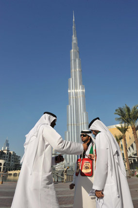 Un grupo de dubait&iacute;es pasea bajo la Burj Dubai. / Efe