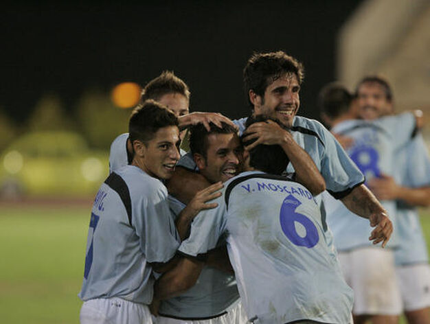 Los jugadores del Poli abrazan al centrocampista por su gol. 

Foto: Javier Alonso