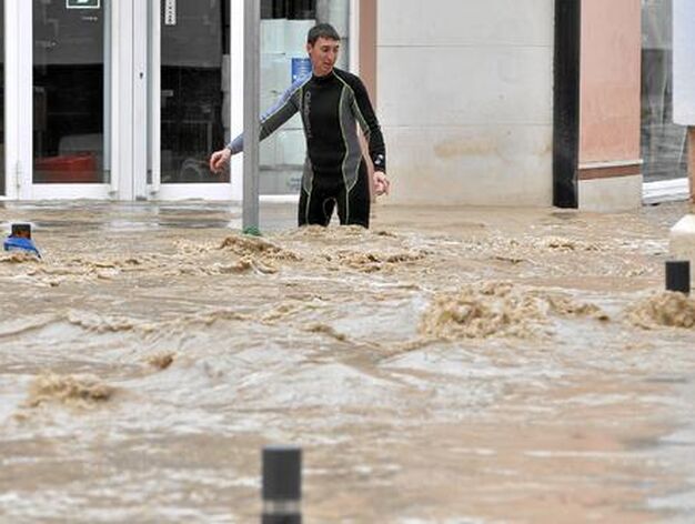 Un vecino, con traje de buzo, intenta caminar por la calle inundada. 

Foto: Manuel G&oacute;mez