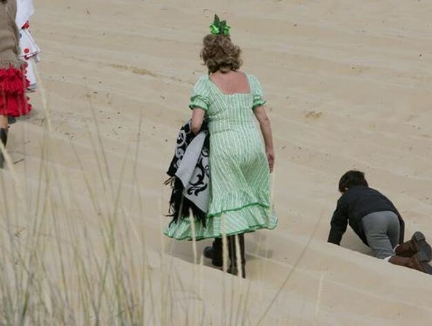 Una peregrina andando por las arenas mientras un ni&ntilde;o juguetea a su lado.

Foto: Pascual