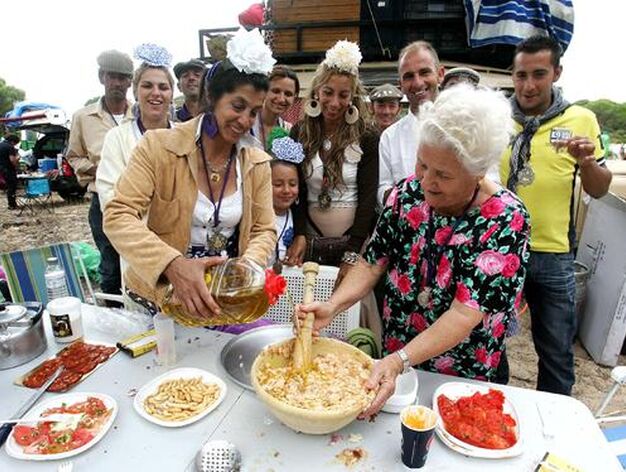 Una veterana rociera prepara la comida con el apoyo de un animado grupo durante el rengue de almuerzo por los parajes del Coto de Do&ntilde;ana. 

Foto: Pascual