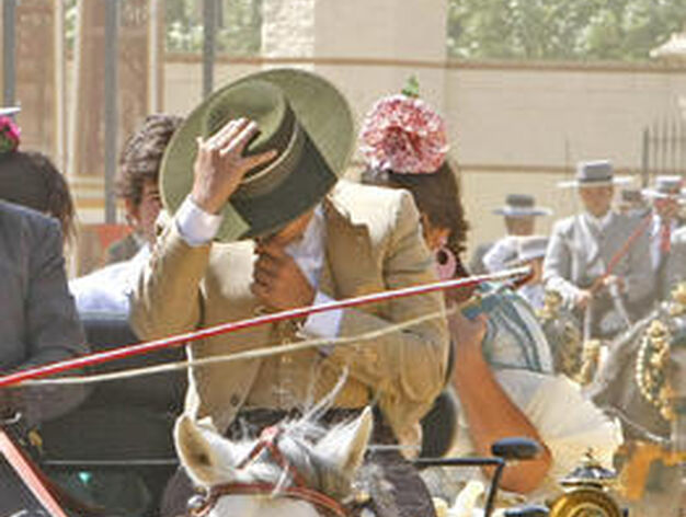 Un cochero se protege la cara con su sombrero del fuerte viento.

Foto: Pascual