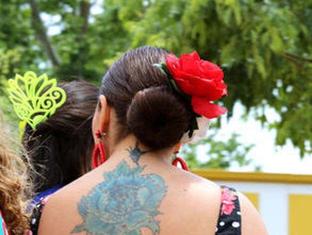 Una mujer vestida de flamenca muestra su tatuaje de la espalda.

Foto: Pascual