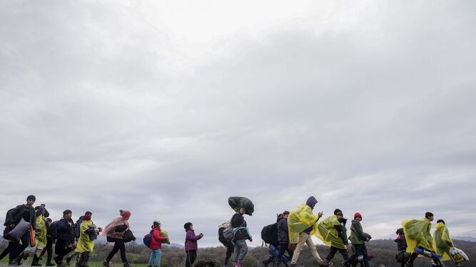 Un grupo de refugiados camina bajo la lluvia a su llegada al campo griego de Idomeni.