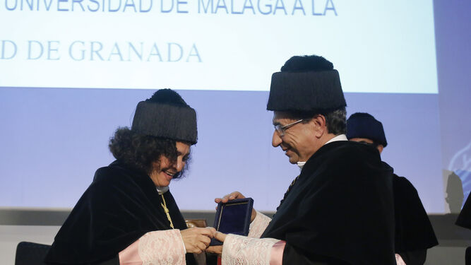 El rector de la UMA entregando la medalla de oro a la rectora de la UGR.