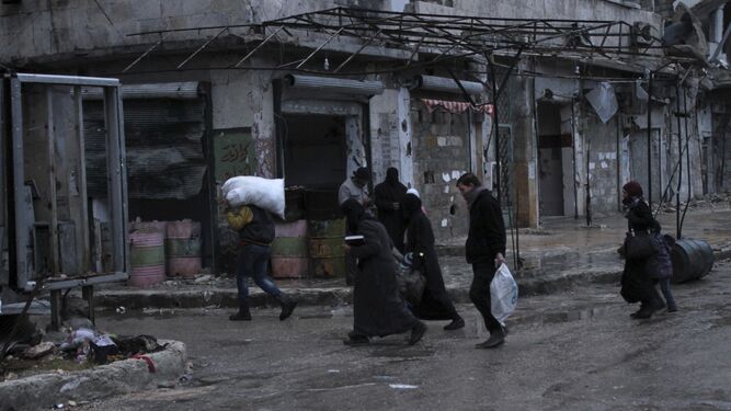 Varias personas cargaban ayer con sus pertenencias por las calles del barrio de Al Mashad, en la zona controlada por los rebeldes en Alepo.