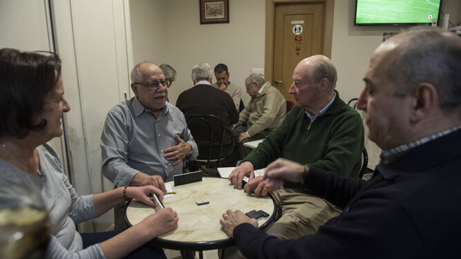 Grupos de amigos se reúnen para jugar al dominó.