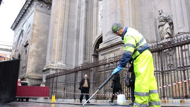 Un trabajador de Inagra rasca cera a las puertas de la Catedral.