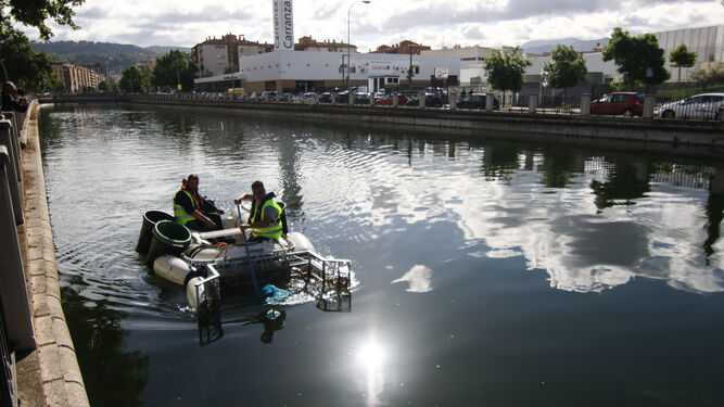 Dos operarios realizan trabajos de limpieza en el río a la altura del Hospital la Inmaculada.
