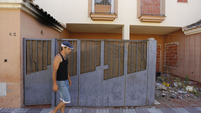 Un hombre pasa ante la puerta de la casa en la que supuestamente ocurrieron los hechos.