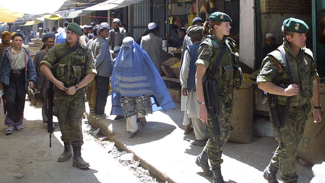 Miembros de unidades de montaña españolas patrullan a pie un mercado en una localidad afgana.