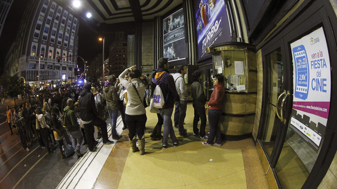 Espectadores hacen cola a las puertas de un cine.