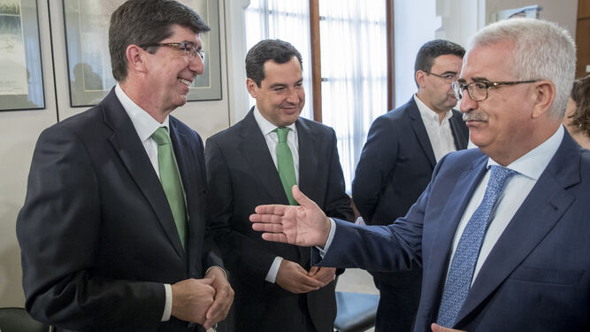 El jefe de Ciudadanos, Juan Marín, conversa con el vicepresidente del Ejecutivo, Manuel Jiménez Barrios, en presencia del presidente del PP-A, Juanma Moreno.