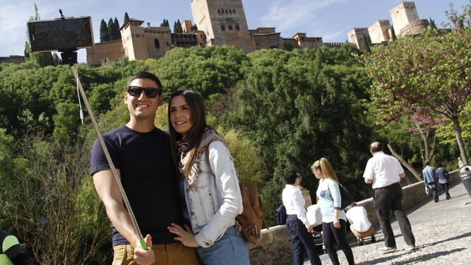 Dos turistas se hacen un 'selfie' con la Alhambra de fondo.