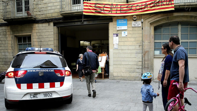 Un vehículo de los Mossos d'Esquadra ante uno de los colegios ocupados en Barcelona.