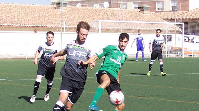 Antonio Peso protege el cuero ante la presión de un jugador del Mancha Real.