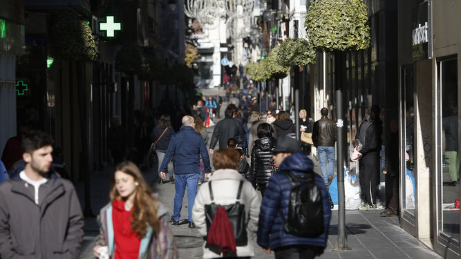 Varias personas transitan por la calle Mesones, en el centro de Granada.