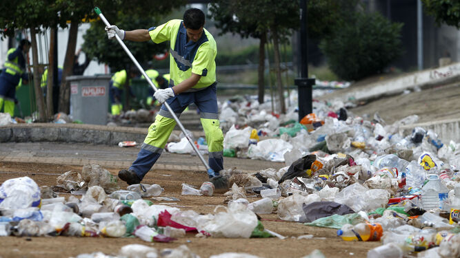 Un trabajador de Inagra limpiando kilos de basura tras unas fiestas.